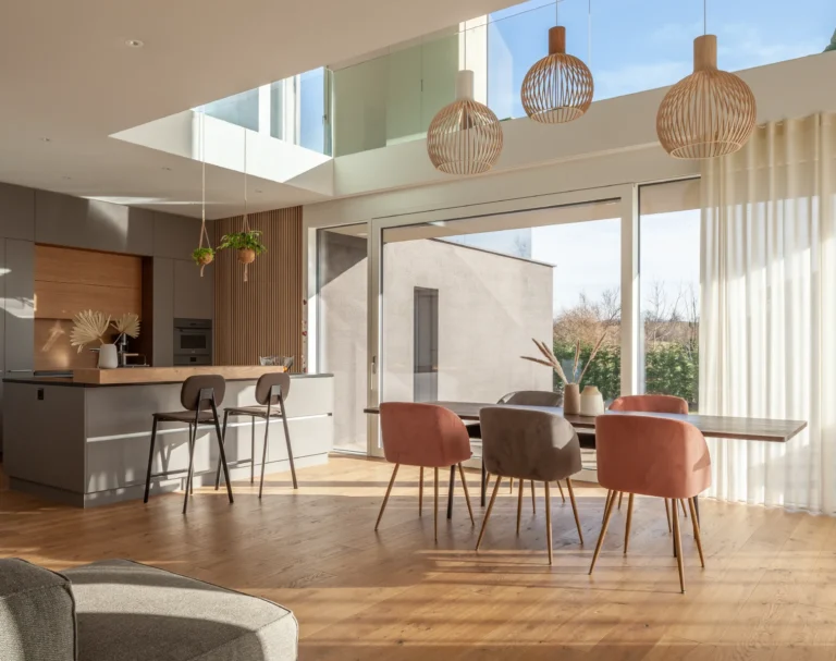 Architektonisch interessanter und in warmen Farben eingerichteter Wohnraum eines grosszügigen Einfamilienhauses im warmen Tageslicht.