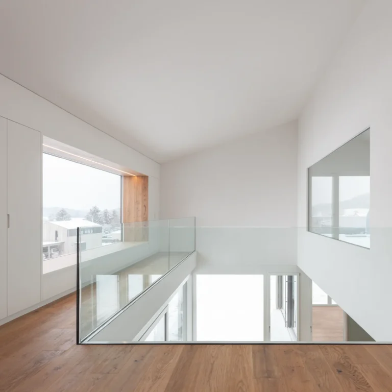 Einblick in eine helle lichtdurchflutete Galerie mit grosszügigen Glasfronten und schönem Sitzfenster.