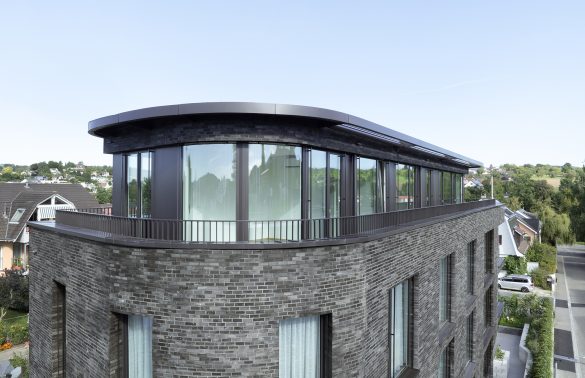 Ansicht eines Attikas eines Mehrfamilienhauses in nordischer Architektur mit runder Fensterfronten.