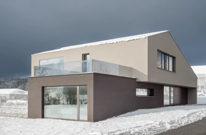 Frontansicht eines grosszügigen und edlen Einfamilienhauses in Gempen im Schnee.