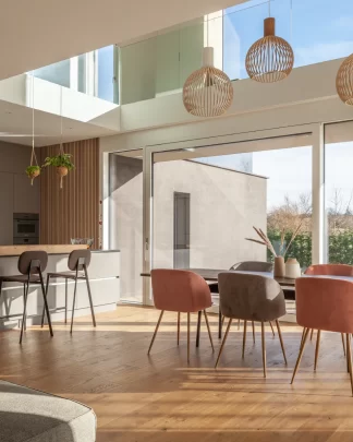 Architektonisch interessanter und in warmen Farben eingerichteter Wohnraum eines grosszügigen Einfamilienhauses im warmen Tageslicht.