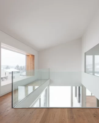 Einblick in eine helle lichtdurchflutete Galerie mit grosszügigen Glasfronten und schönem Sitzfenster.