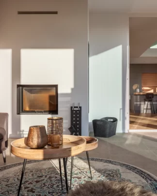 warm, edel und modern eingerichtete Orangerie eines Wohnhauses mit Cheminee in warmen Licht.