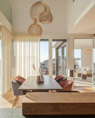 Blick von Küche aus auf den Esstisch eines freundlich, hell und warm eingerichteten Einfamlienhauses.auses